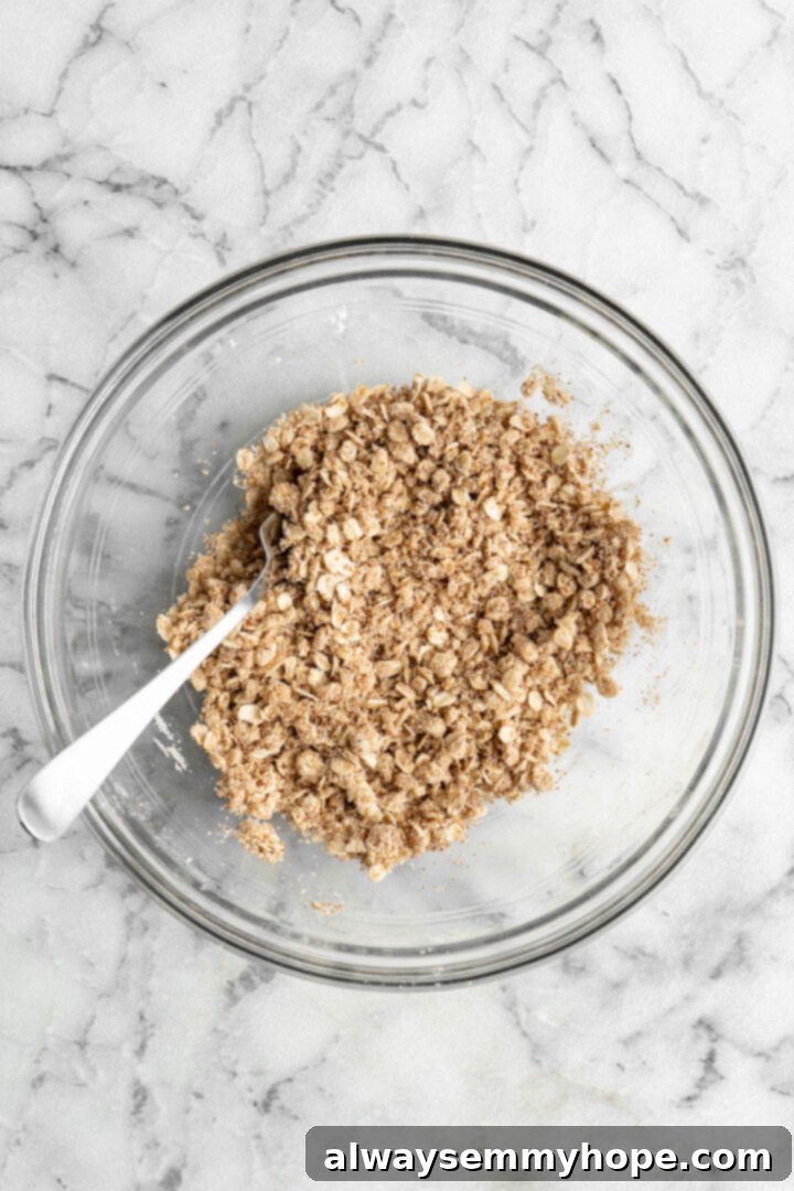 This vegan strawberry crumble is easy as can be! You only need 5 ingredients and a few minutes of assembly for the perfect summer dessert. Overhead view of vegan strawberry crumble topping