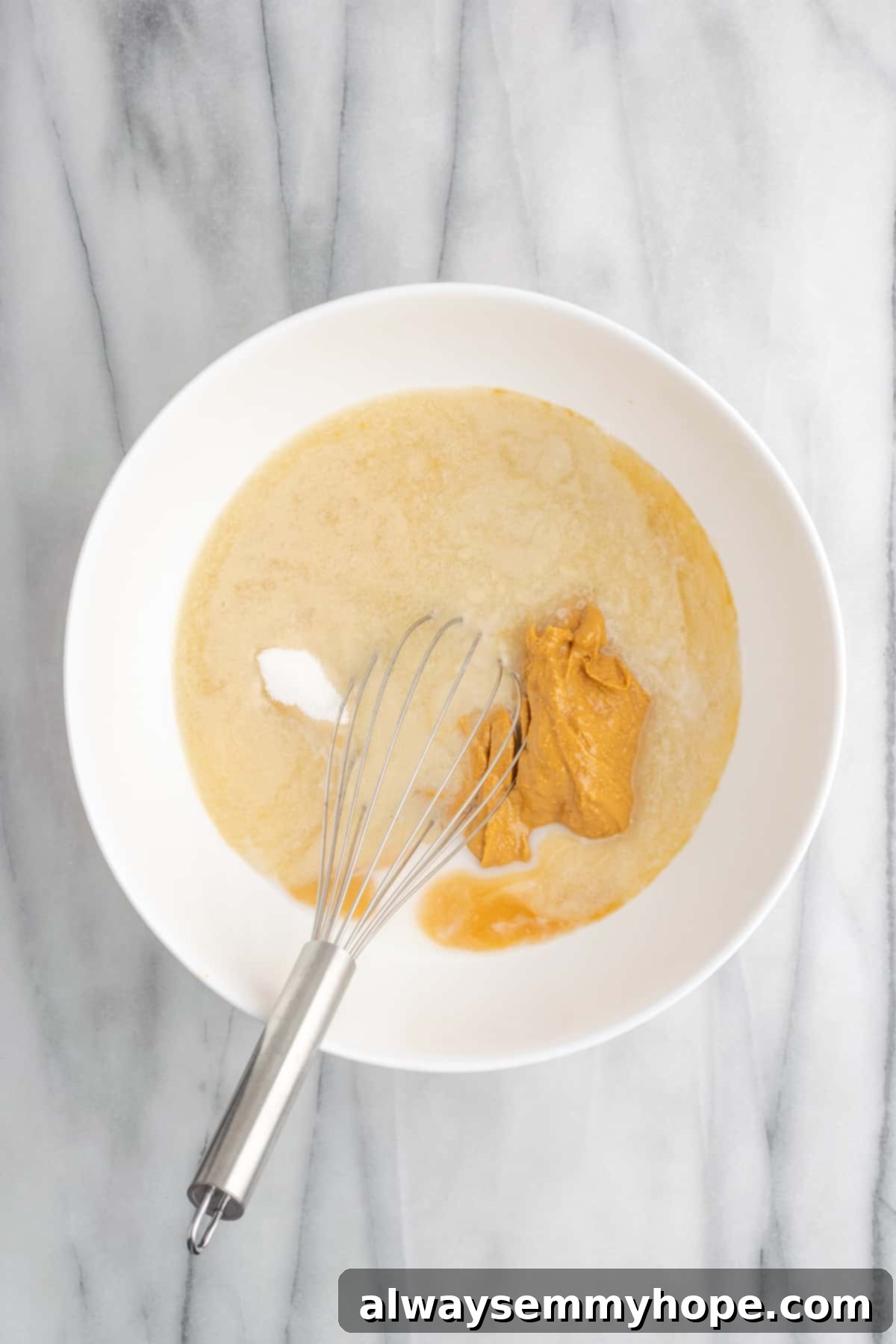 Prepare a creamy peanut butter frosting with these simple ingredients for your delicious vegan cake. A bowl filled with softened vegan butter, smooth peanut butter, and confectioners' sugar, the base ingredients for the rich peanut butter frosting.