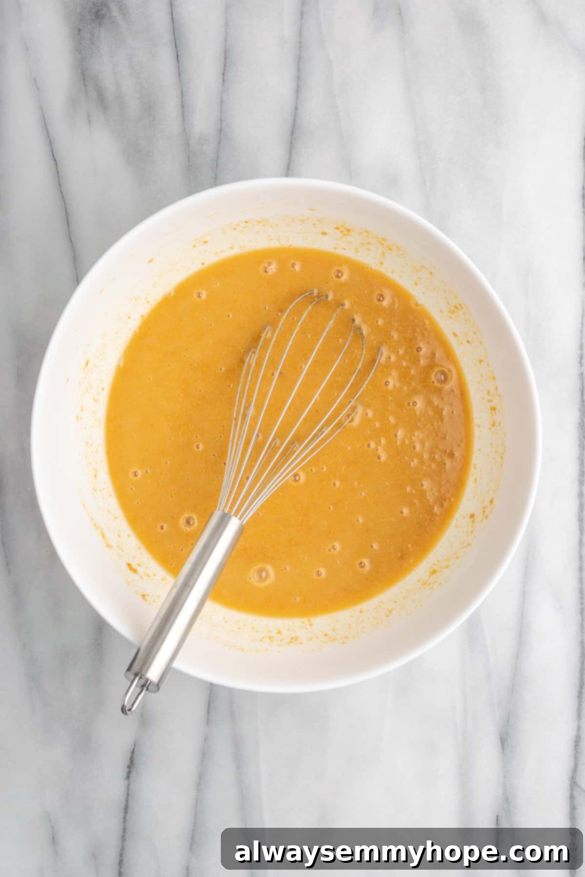 A glimpse into the perfectly blended wet ingredients for this delicious vegan peanut butter cake recipe. A close-up shot of the mixed wet ingredients for the vegan peanut butter cake, showing a smooth, creamy batter before dry ingredients are added.