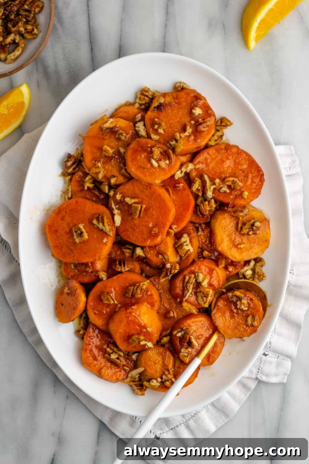 This easy, vegan candied yams recipe makes a sweet, sticky, and delicious plant-based side dish to accompany any special meal. A serving plate of glistening, perfectly caramelized vegan candied yams, ready to be enjoyed.