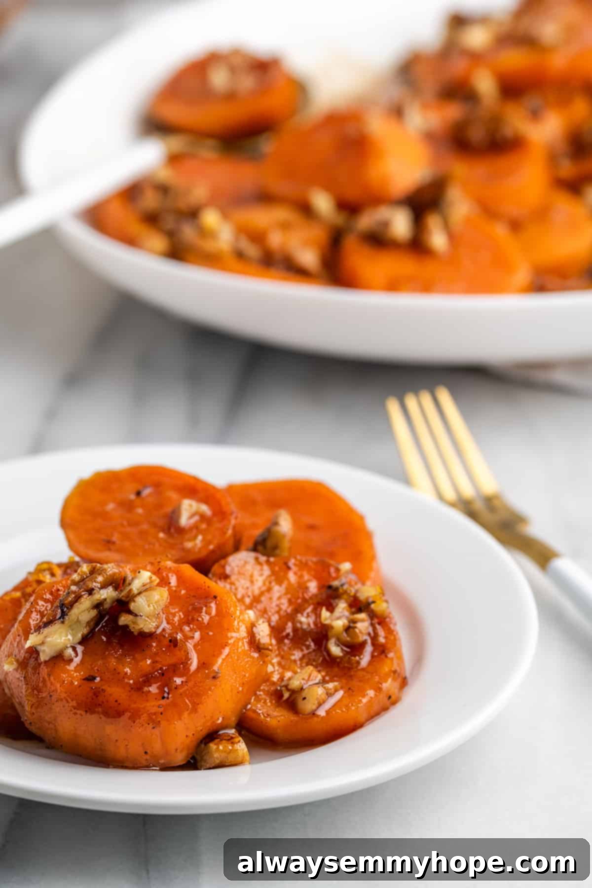 A plate of warm candied yams with a fork, showcasing their deliciousness. A single serving of candied yams on a white plate with a fork, highlighting their sticky, tender texture.
