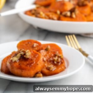 Sweet Potato Jewels 2 A plate of vegan candied yams with a fork, showing the delicious sticky glaze.