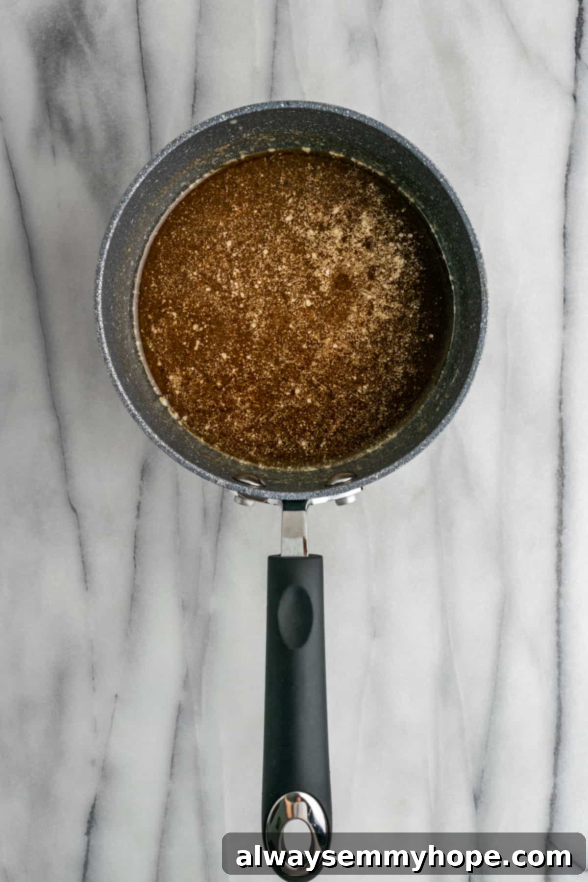 The finished, smooth sauce for candied yams in a saucepan, ready for the yams. The smooth, dark amber candied yam sauce after all ingredients have been thoroughly mixed in a saucepan.