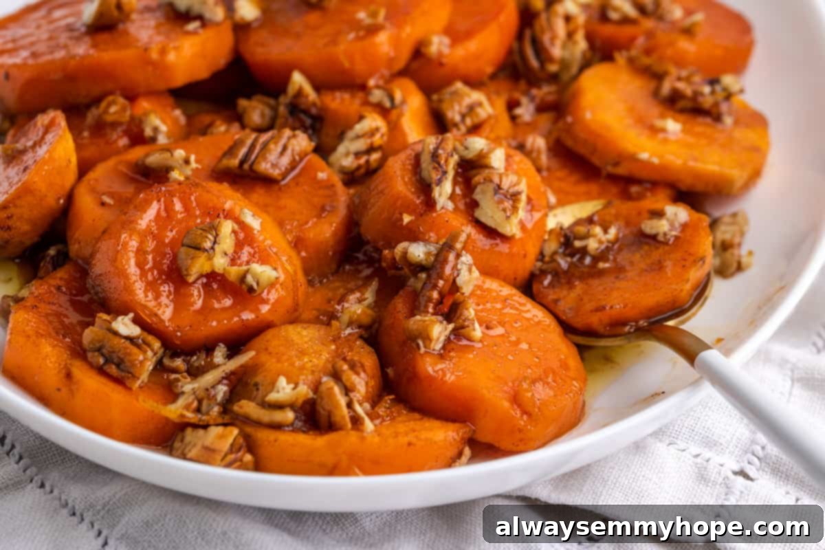 Close-up of perfectly baked and glazed candied yams. A close-up view of baked candied yams, showing their tender texture and shiny, sticky glaze.