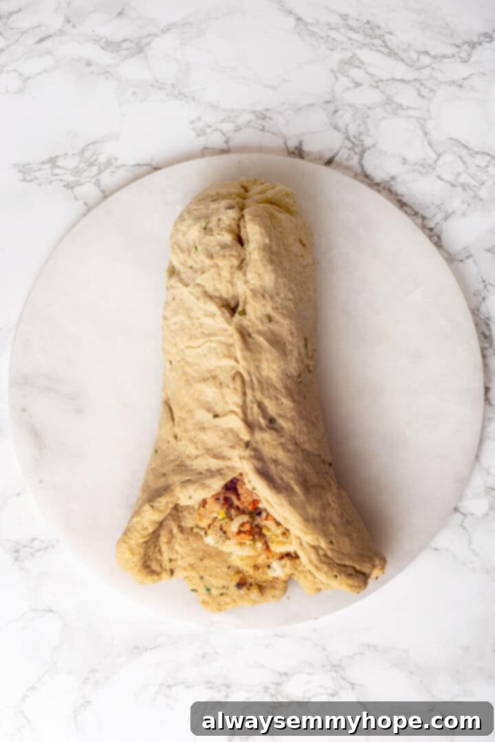 This homemade vegan turkey recipe is supremely flavourful and the perfect addition to any Thanksgiving table or holiday dinner! Overhead view of vegan turkey being stuffed