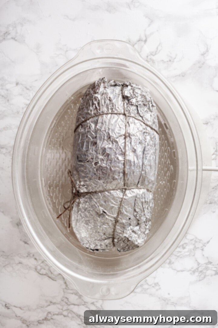 This homemade vegan turkey recipe is supremely flavourful and the perfect addition to any Thanksgiving table or holiday dinner! Overhead view of vegan turkey wrapped in foil for steaming