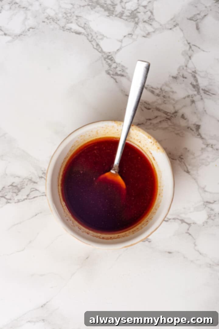 This homemade vegan turkey recipe is supremely flavourful and the perfect addition to any Thanksgiving table or holiday dinner! Overhead view of glaze for vegan turkey in bowl with spoon