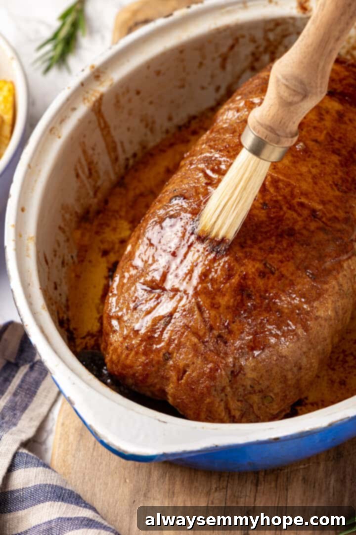 This homemade vegan turkey recipe is supremely flavourful and the perfect addition to any Thanksgiving table or holiday dinner! Brushing glaze onto vegan turkey in baking dish