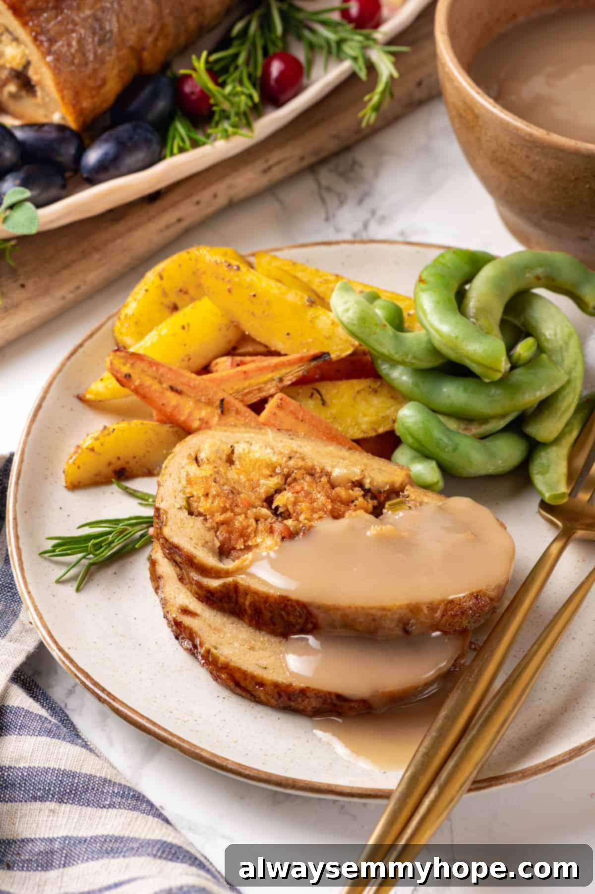 This homemade vegan turkey recipe is supremely flavourful and the perfect addition to any Thanksgiving table or holiday dinner! Vegan turkey slices on plate with gravy, roasted vegetables, and edamame