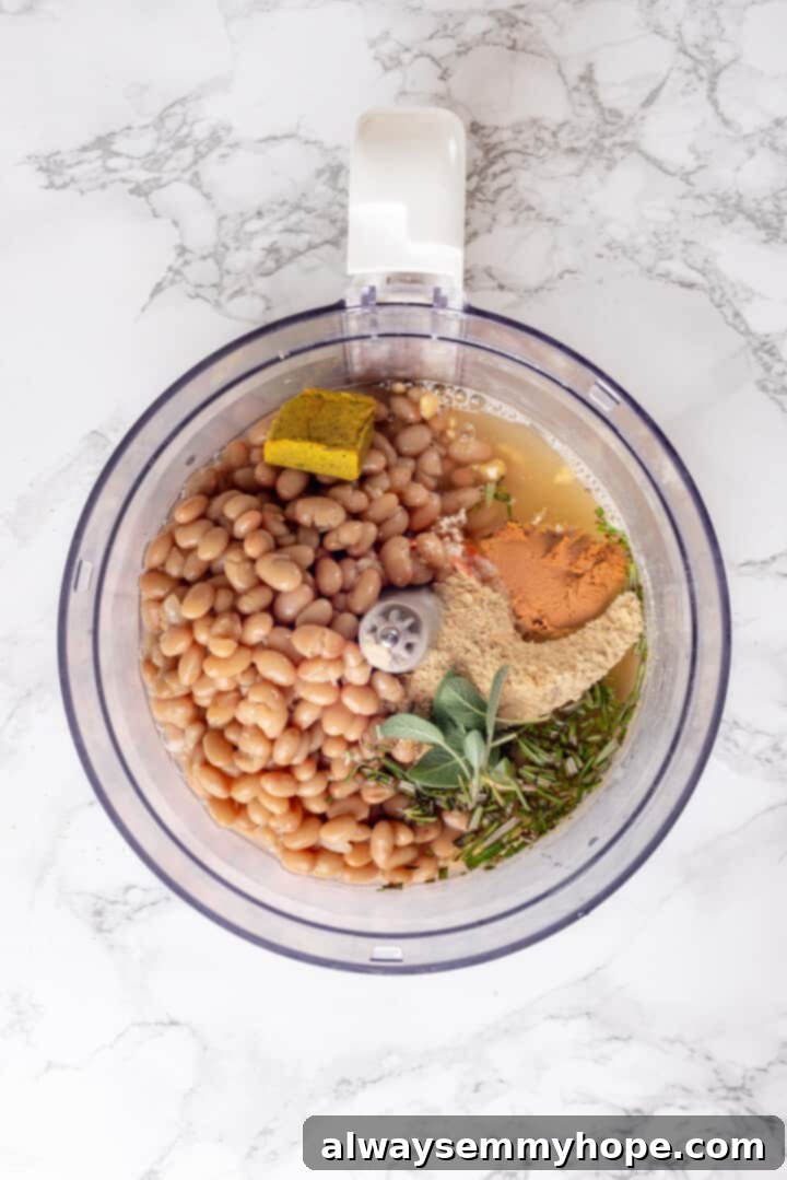 This homemade vegan turkey recipe is supremely flavourful and the perfect addition to any Thanksgiving table or holiday dinner! Overhead view of beans and seasonings in food processor before pureeing