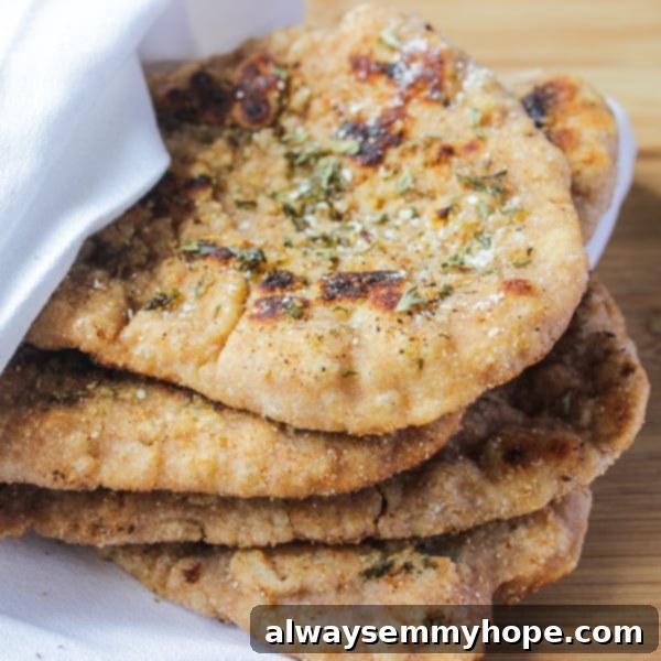 Homemade Whole Wheat Naan Bread Recipe Pile of freshly baked homemade whole wheat naan bread, wrapped in a white cloth.
