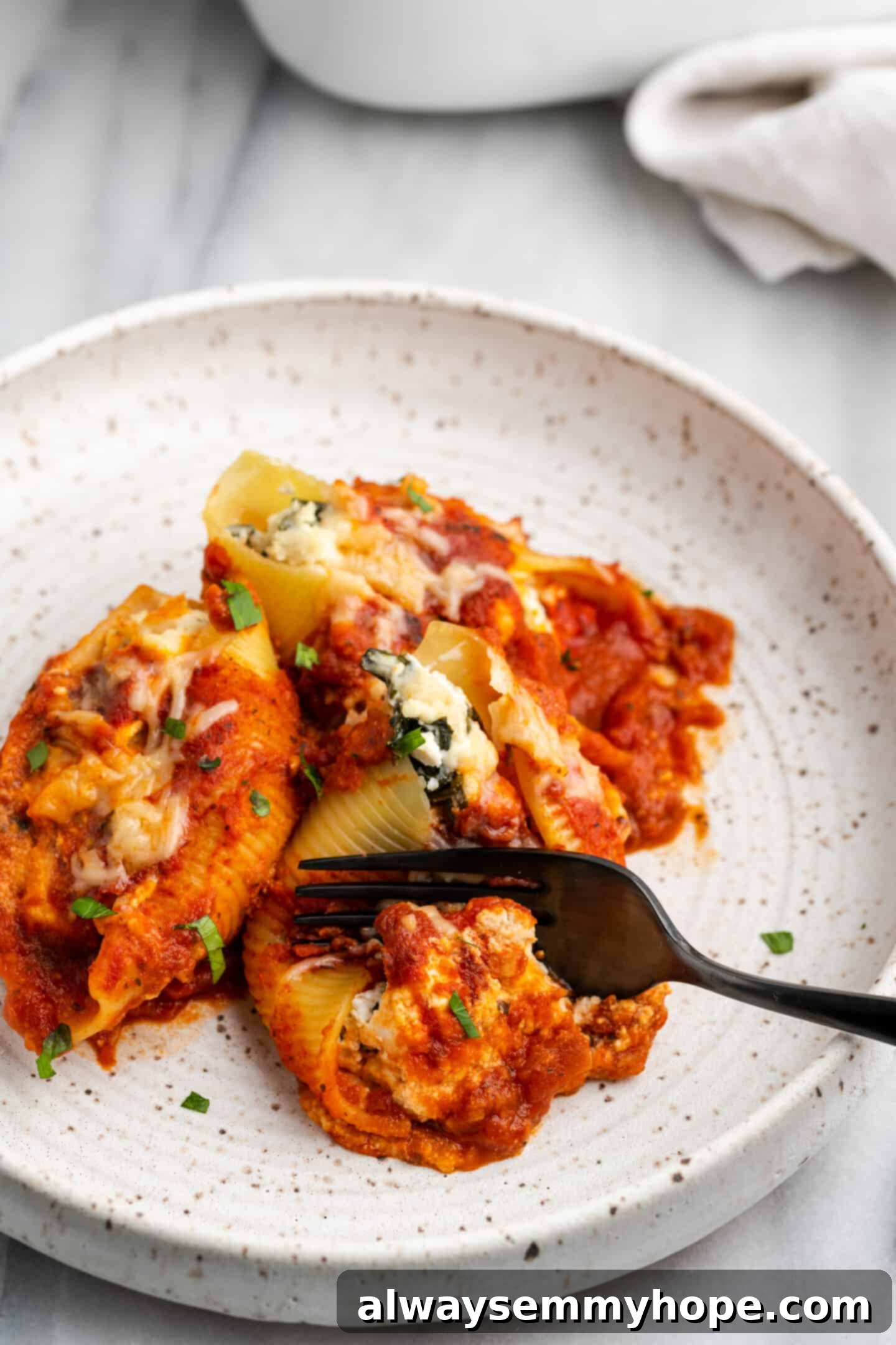 Creamy Vegan Stuffed Shells 3 Closeup shot of vegan stuffed shells with a fork lifting one piece