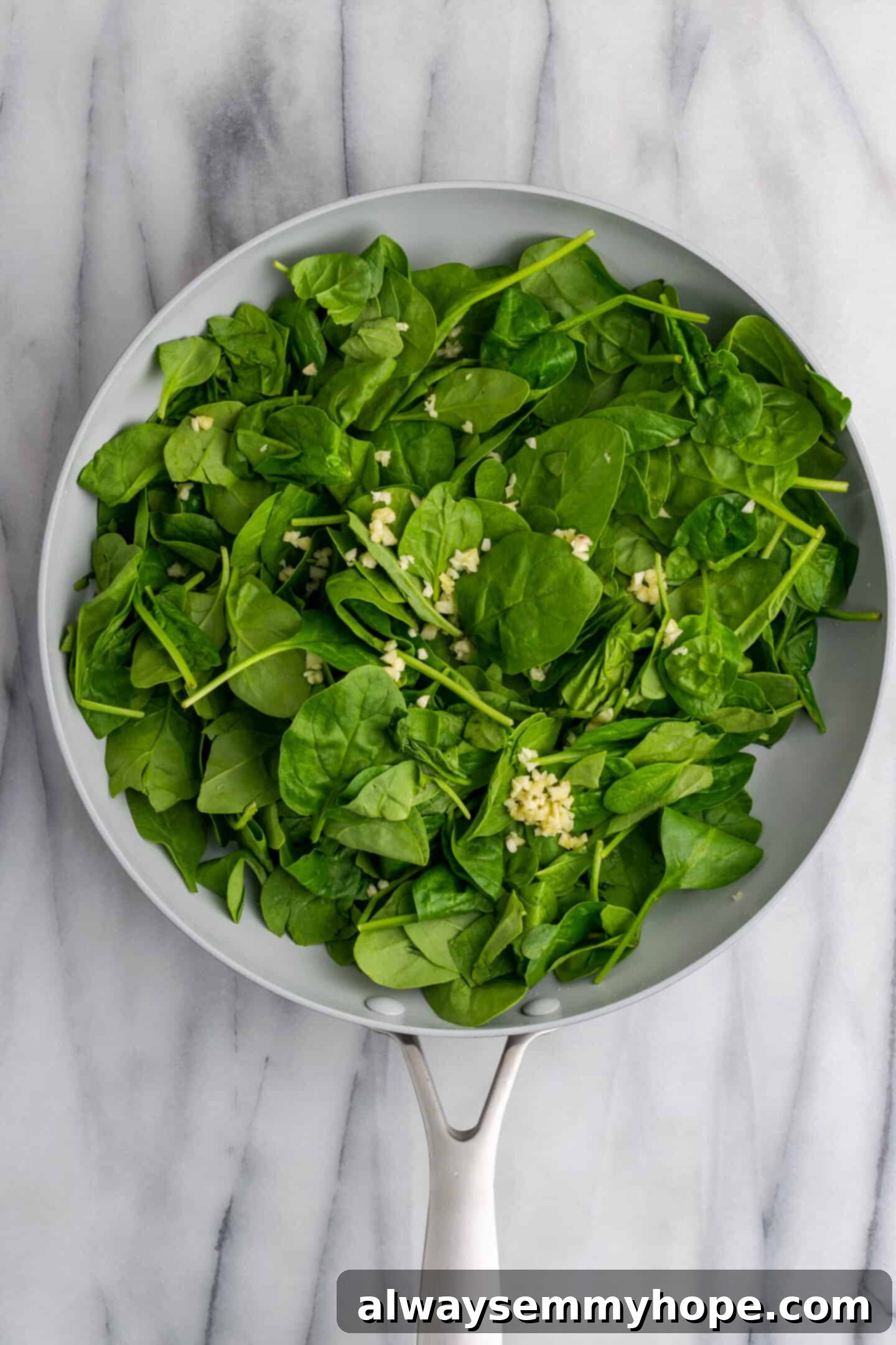 Creamy Vegan Stuffed Shells 8 Garlic and spinach beginning to sauté in a skillet