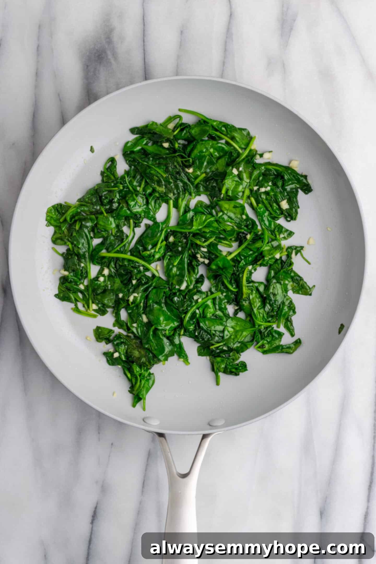 Creamy Vegan Stuffed Shells 9 Fully wilted spinach with garlic in a pan, ready for the next step
