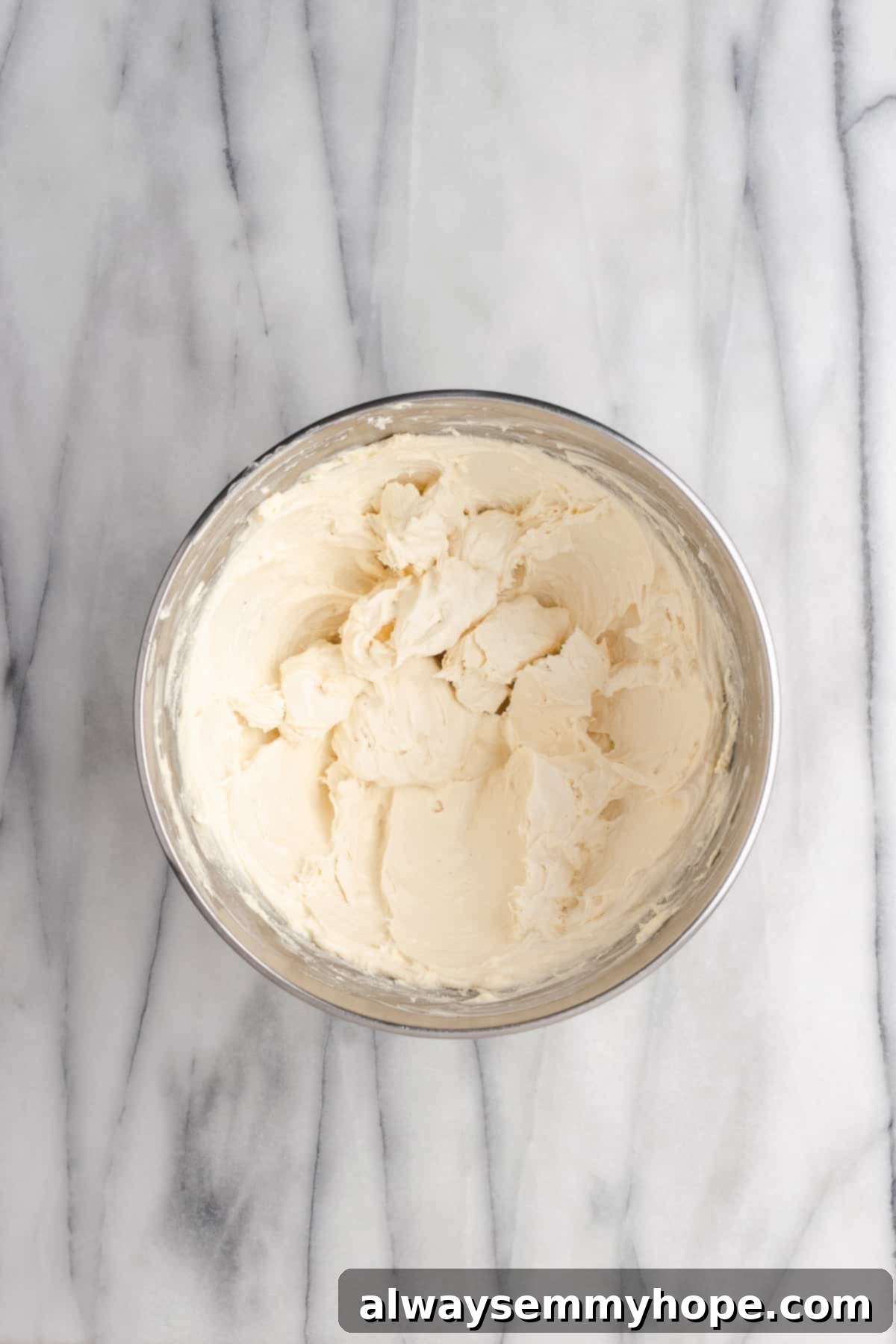 Tropical Vegan Coconut Cake 13 More powdered sugar being added to the vegan cream cheese frosting, gradually building volume.