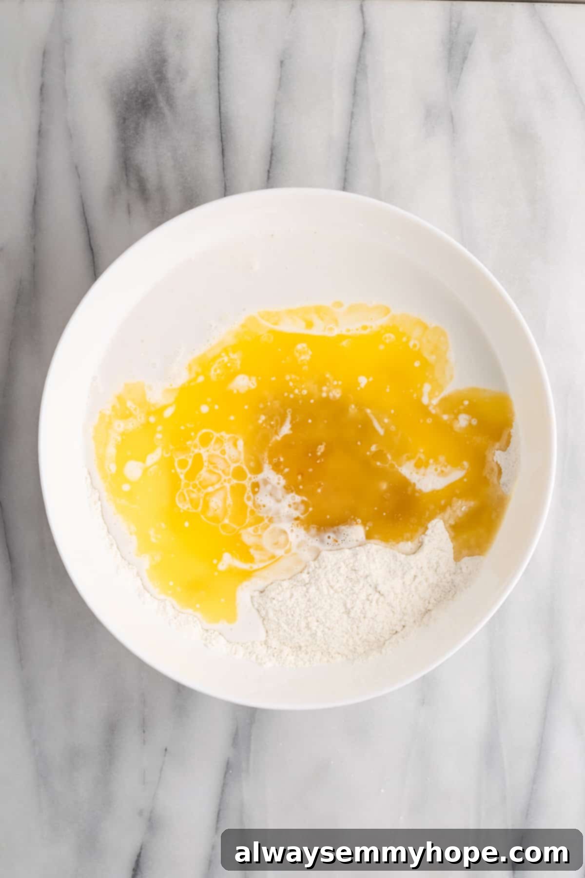 Tropical Vegan Coconut Cake 6 The process of adding wet ingredients to the dry mixture for vegan coconut cake batter, ensuring proper hydration.