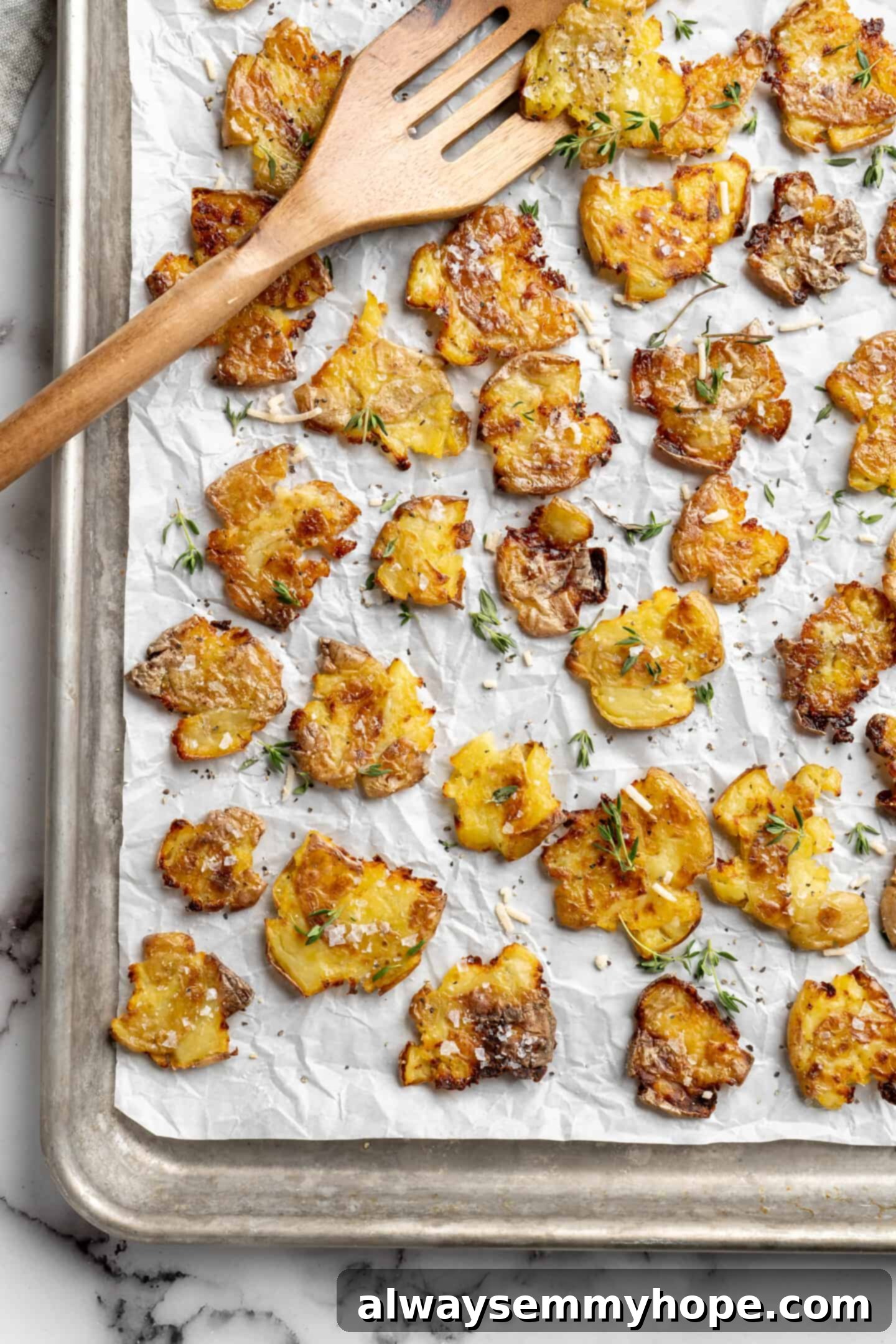 A sheet pan full of golden crispy smashed potatoes, ready to be served