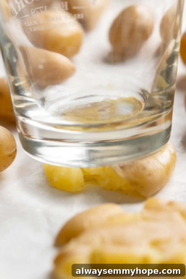 Process of crushing baby potatoes with the bottom of a glass