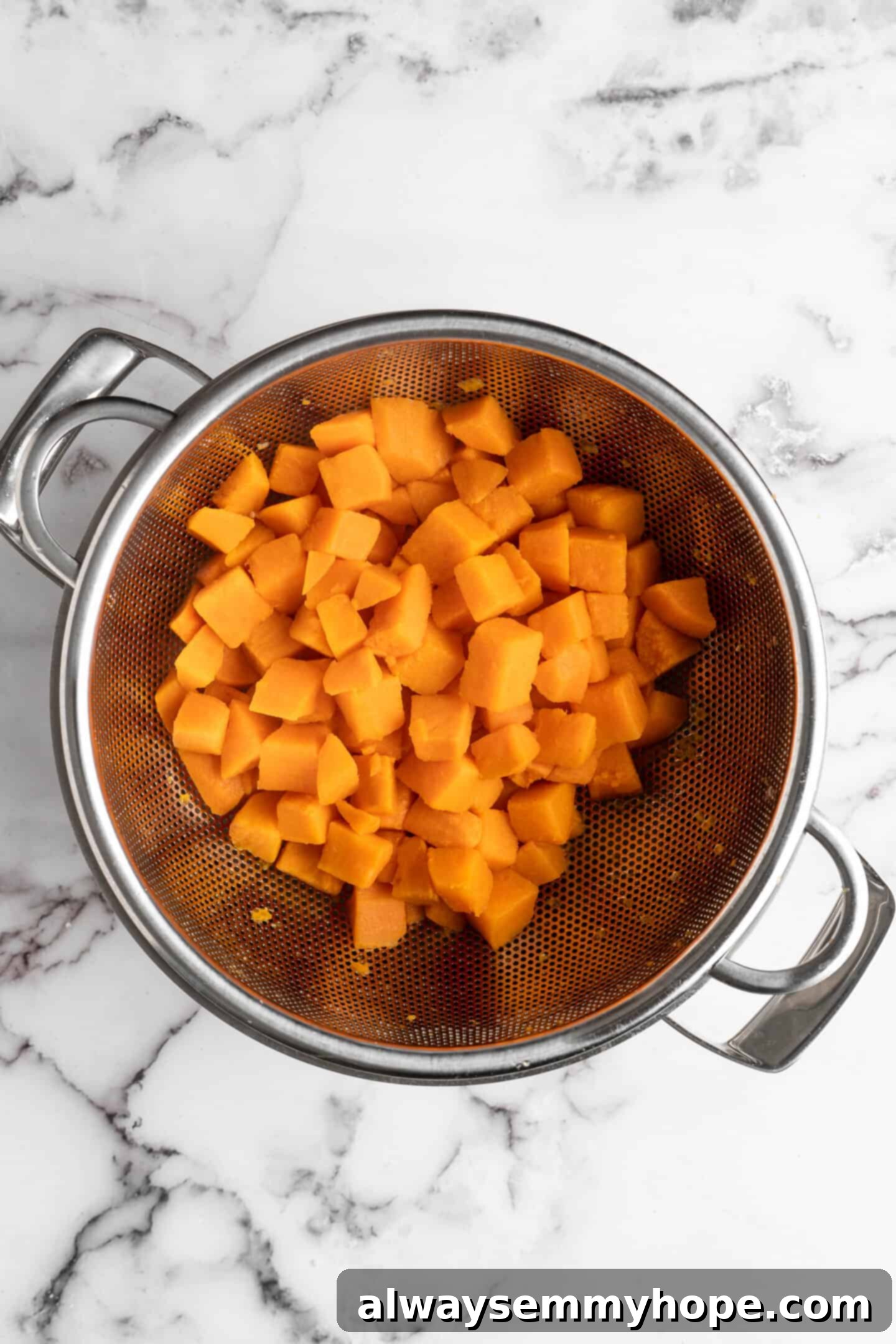 This recipe for vegan mashed sweet potatoes is like a whole holiday celebration in a bowl, but easy enough to make on a busy weeknight! Boiled and thoroughly drained sweet potato cubes in a pot, ready for mashing.