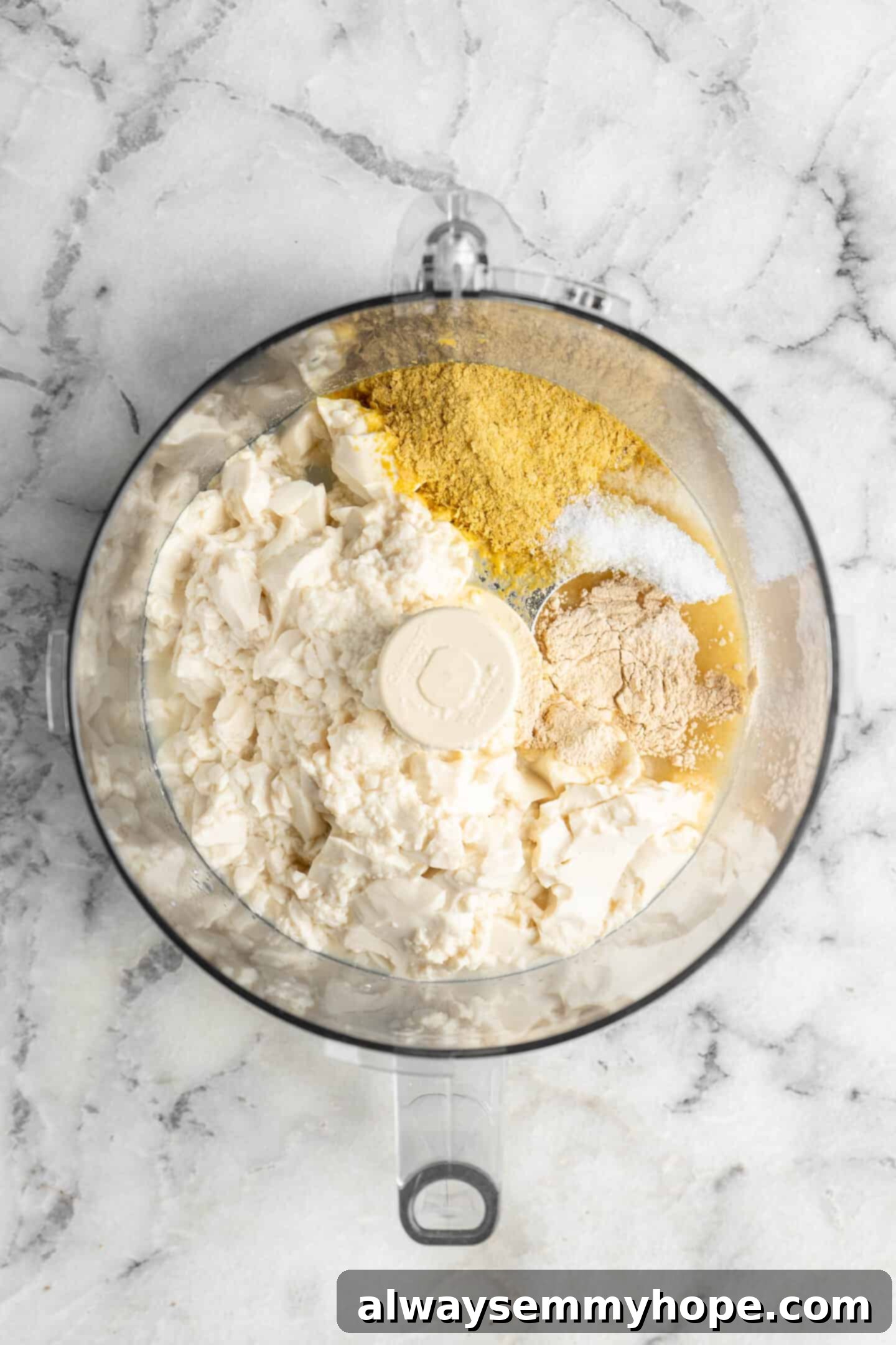 Combine all ingredients in a food processor for quick blending. All vegan ricotta ingredients in a food processor, ready to blend.