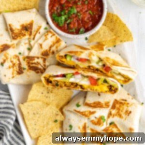 A plate with two whole vegan crunchwrap supremes, one crunchwrap supreme cut in half, some tortilla chips, and a bowl of salsa
