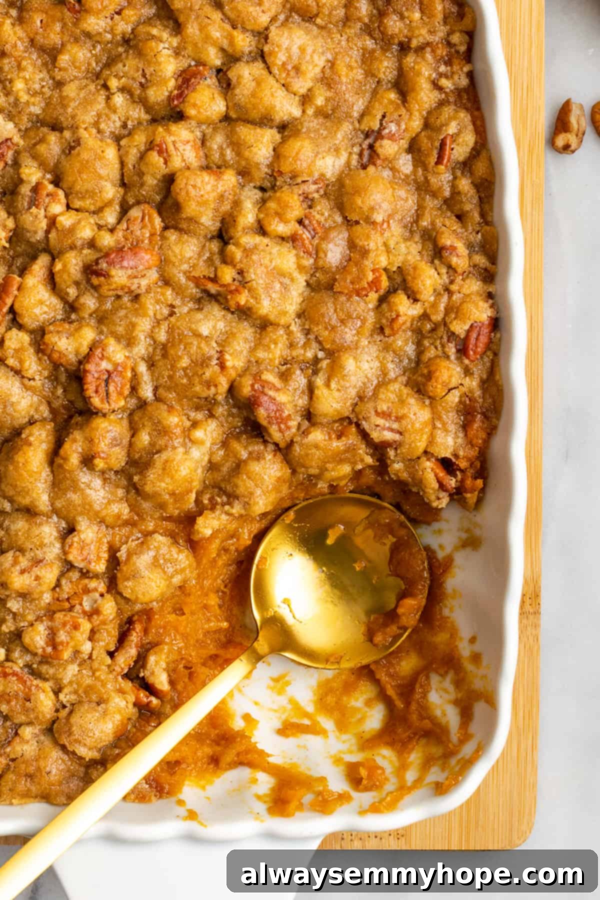 This rich and creamy vegan sweet potato soufflé recipe is a cozy Thanksgiving side. It's entirely vegan, and can easily be made gluten-free. A casserole dish filled with golden-brown vegan sweet potato soufflé, with a corner serving removed and a spoon poised in the dish.