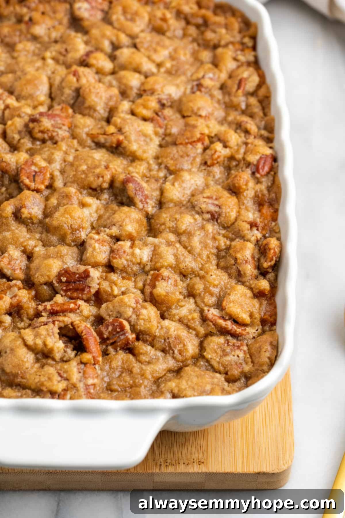 This rich and creamy vegan sweet potato soufflé recipe is a cozy Thanksgiving side. It's entirely vegan, and can easily be made gluten-free. A close-up, inviting view of a perfectly baked sweet potato soufflé in a casserole dish, highlighting its creamy texture and crunchy pecan topping.