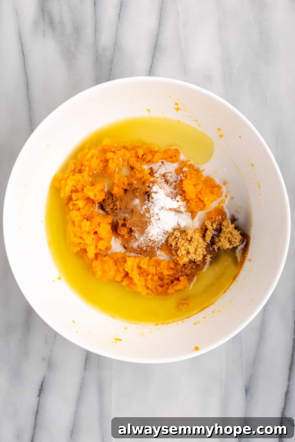This rich and creamy vegan sweet potato soufflé recipe is a cozy Thanksgiving side. It's entirely vegan, and can easily be made gluten-free. A mixing bowl brimming with creamy mashed sweet potatoes, vegan butter, maple syrup, non-dairy milk, fragrant cinnamon, and vanilla, ready to be blended.