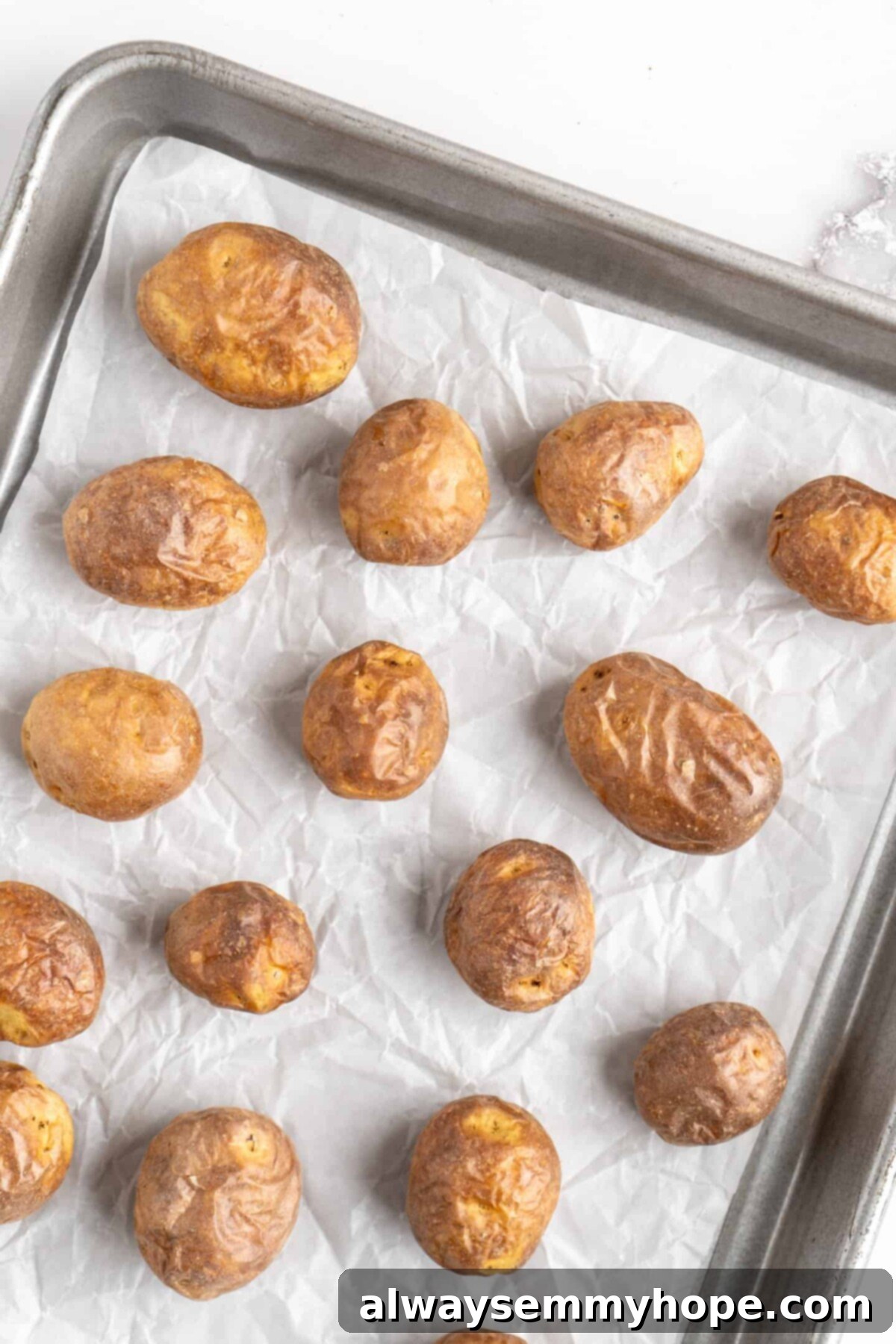 This air fryer smashed potatoes recipe is salty, crispy on the outside, and light and fluffy on the inside. It's an easy side dish, and vegan! Cookied baby potatoes on a baking sheet