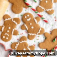 A few decorated gingerbread men next to a few undecorated gingerbread men, surrounded by candy canes and a rolling pin