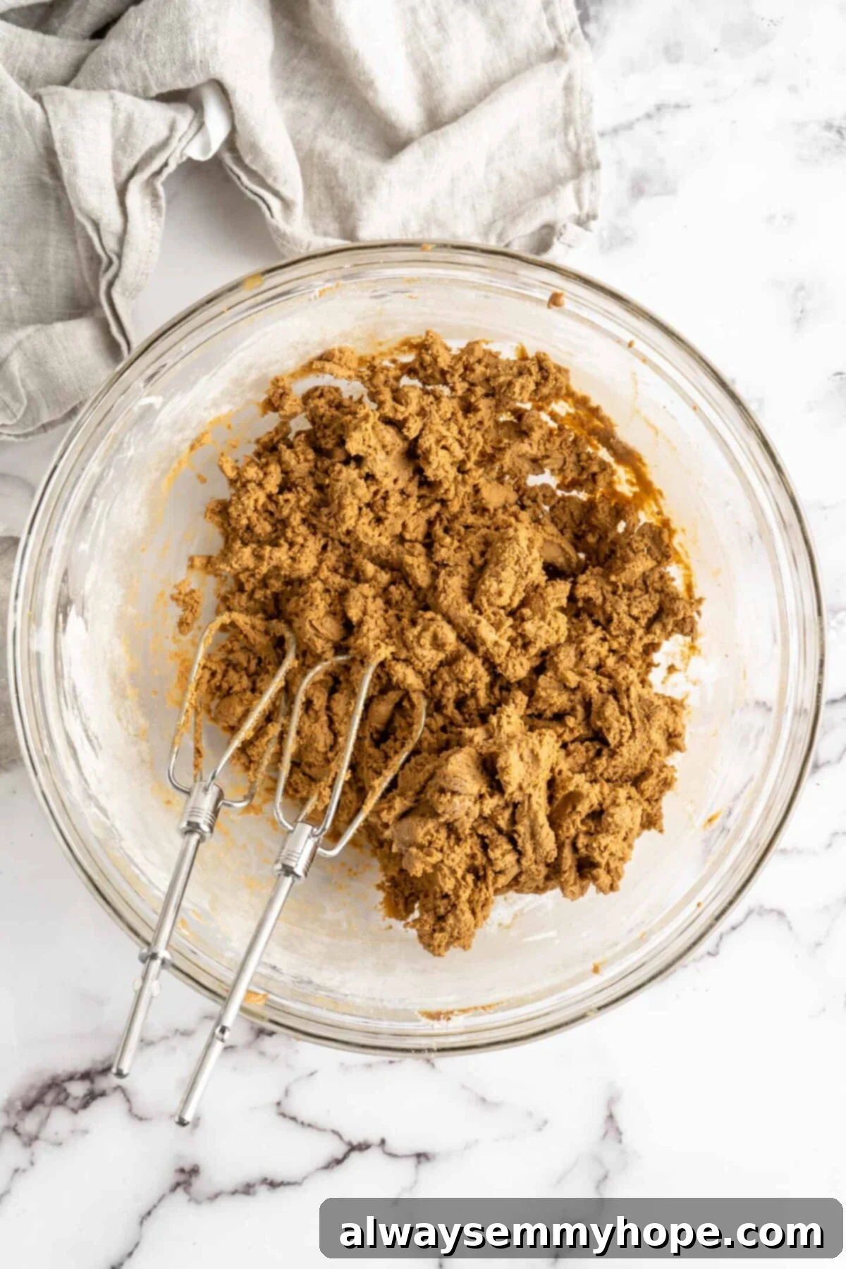 A mixing bowl with gingerbread men dough and an electric mixer