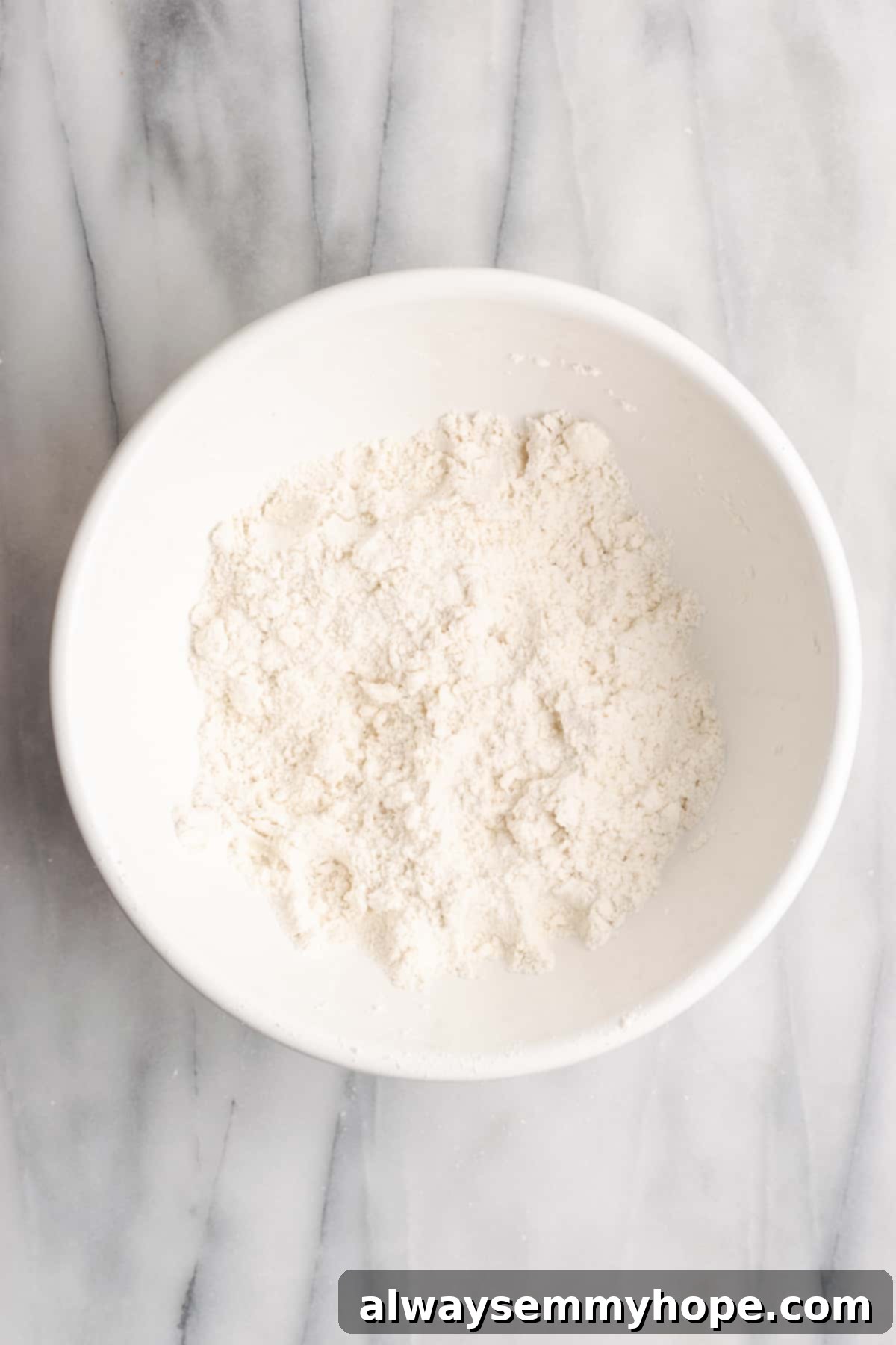 A mixing bowl with vegan butter worked into a flour mixture