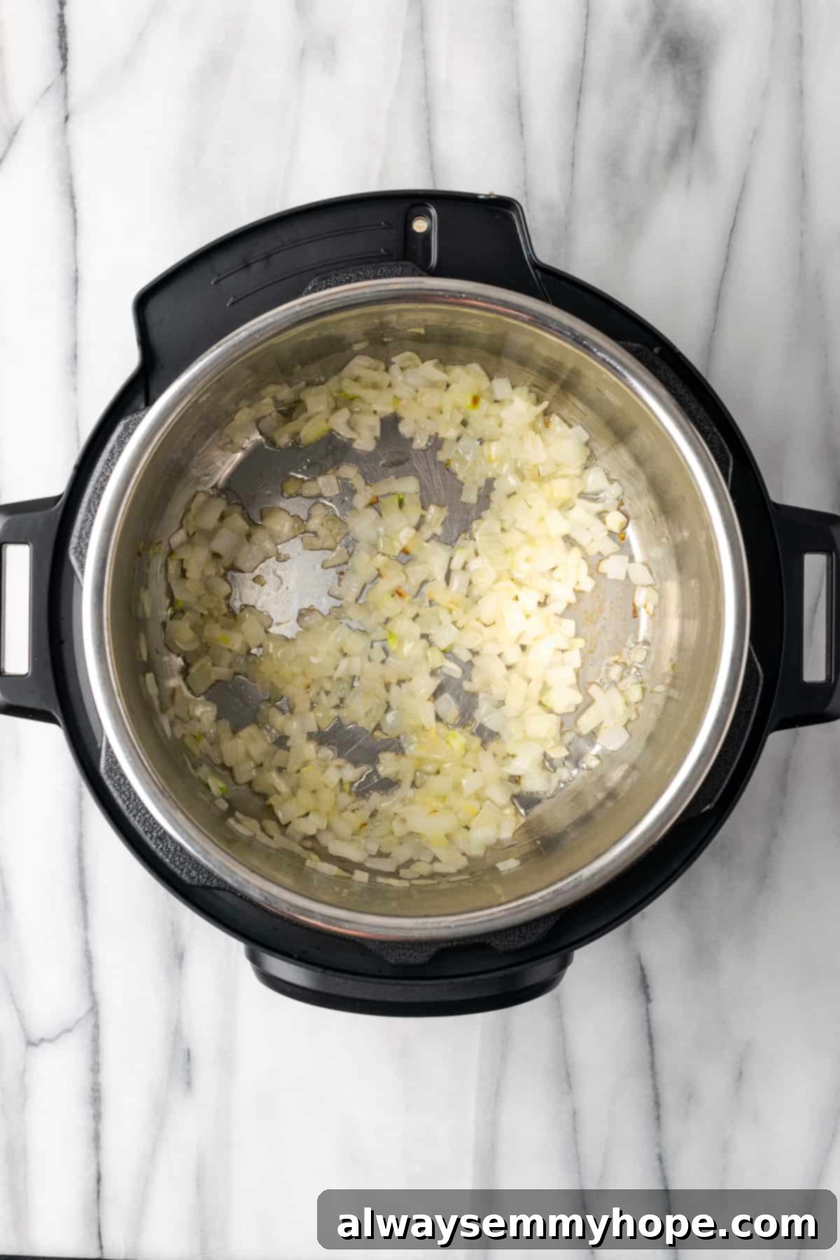 This creamy vegan Instant Pot potato soup recipe is hearty, comforting, and perfect for winter, plus it's easy and quick to make! An Instant Pot with diced onions cooking in a small amount of oil, turning translucent and fragrant.
