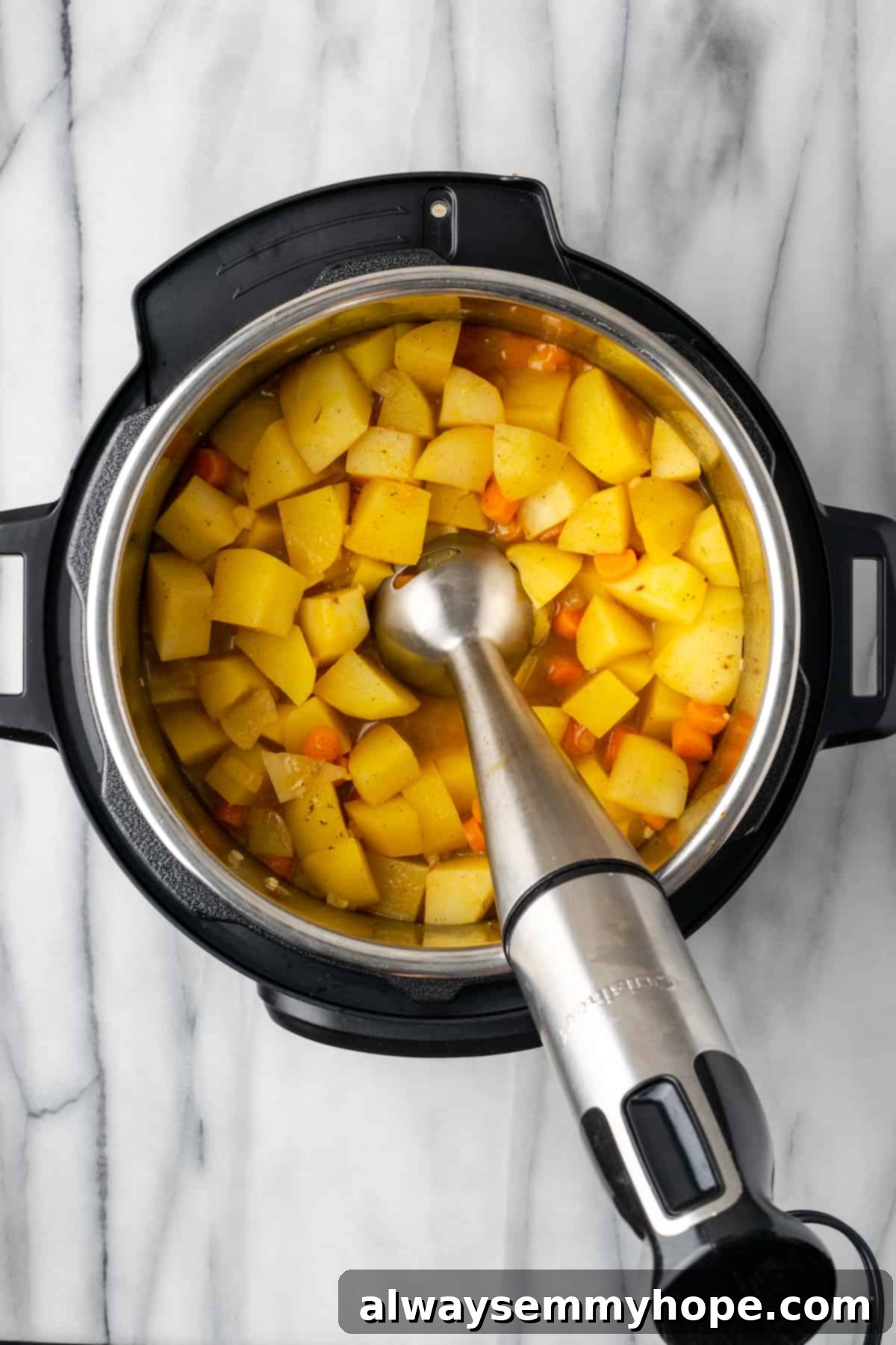 This creamy vegan Instant Pot potato soup recipe is hearty, comforting, and perfect for winter, plus it's easy and quick to make! An immersion blender actively puréeing cooked potatoes, carrots, onions, and vegetable broth directly inside the Instant Pot, creating a smooth soup base.