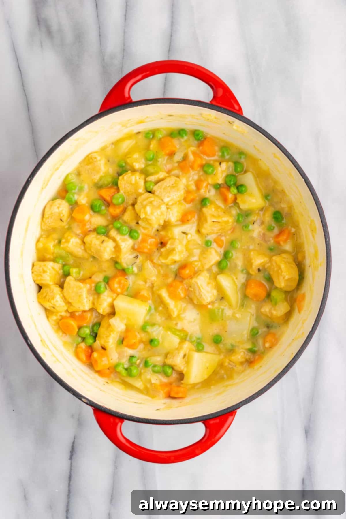 A Dutch oven completely filled with the mixed vegan chicken pot pie filling, ready to be transferred to the casserole dish.
