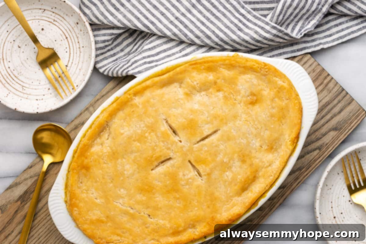 An overhead shot of a freshly baked vegan pot pie casserole, golden and bubbly, placed on a wooden table alongside clean plates and cutlery, inviting guests to serve themselves.