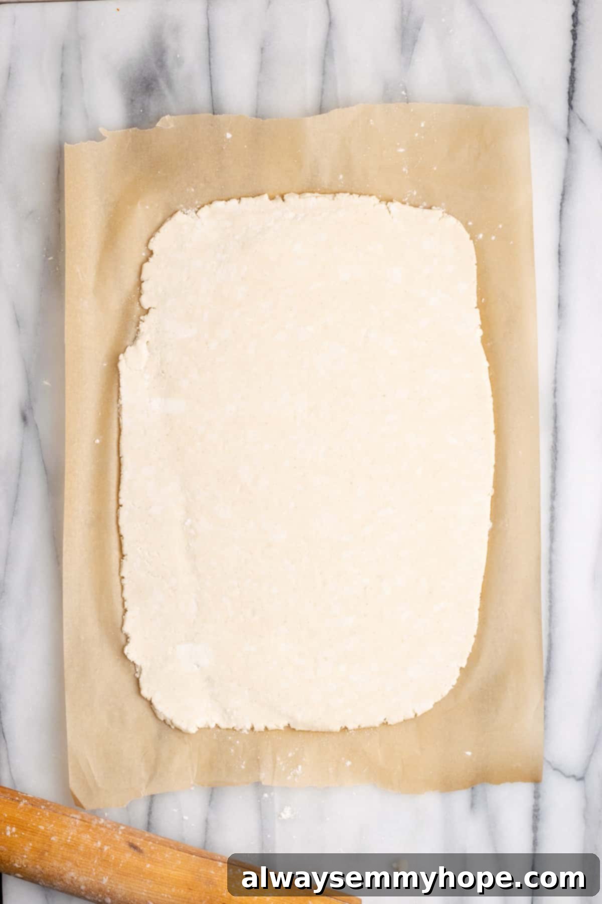 A rectangular sheet of vegan puff pastry laid out on a piece of parchment paper, ready to be shaped for the casserole.
