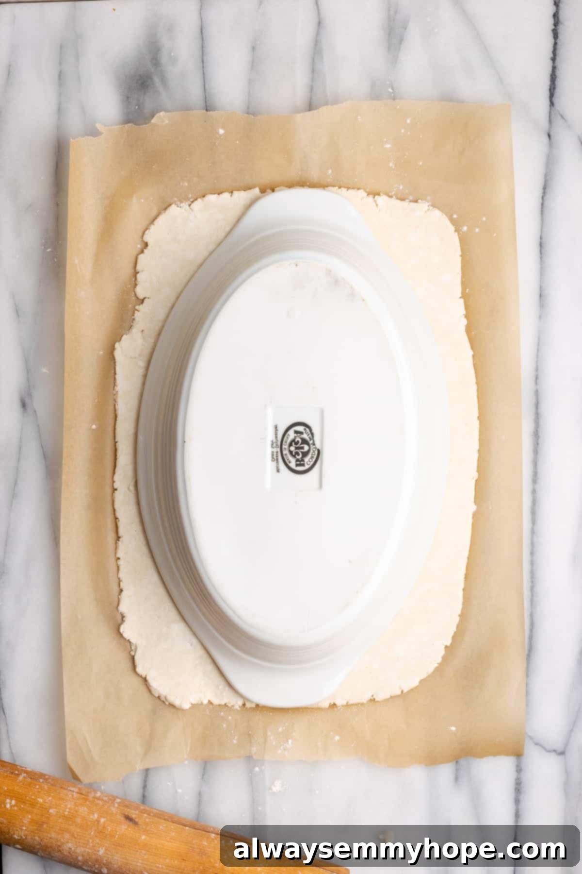 A casserole dish inverted on a sheet of vegan puff pastry, demonstrating how to measure and trim the pastry to the correct size.