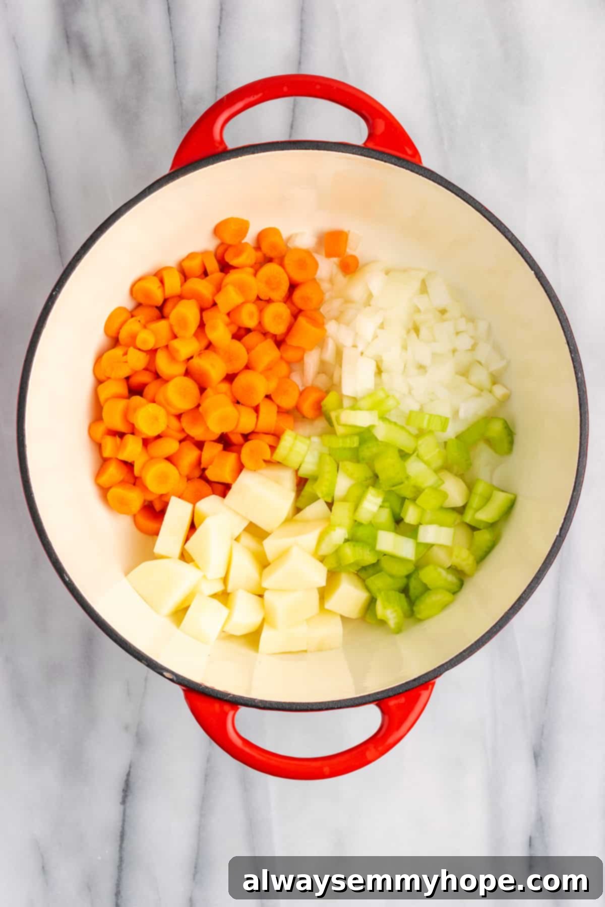 Raw carrots, potatoes, celery, and onions simmering in olive oil in a Dutch oven, starting to soften.