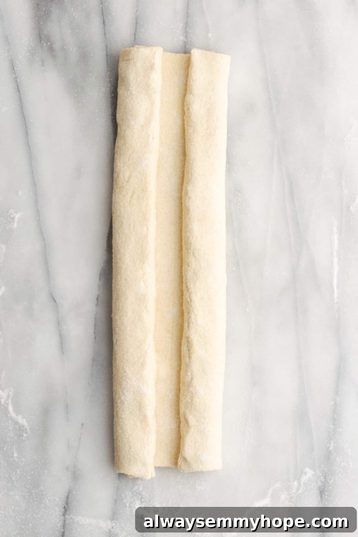 A rectangle of puff pastry dough with both sides folded in towards the middle