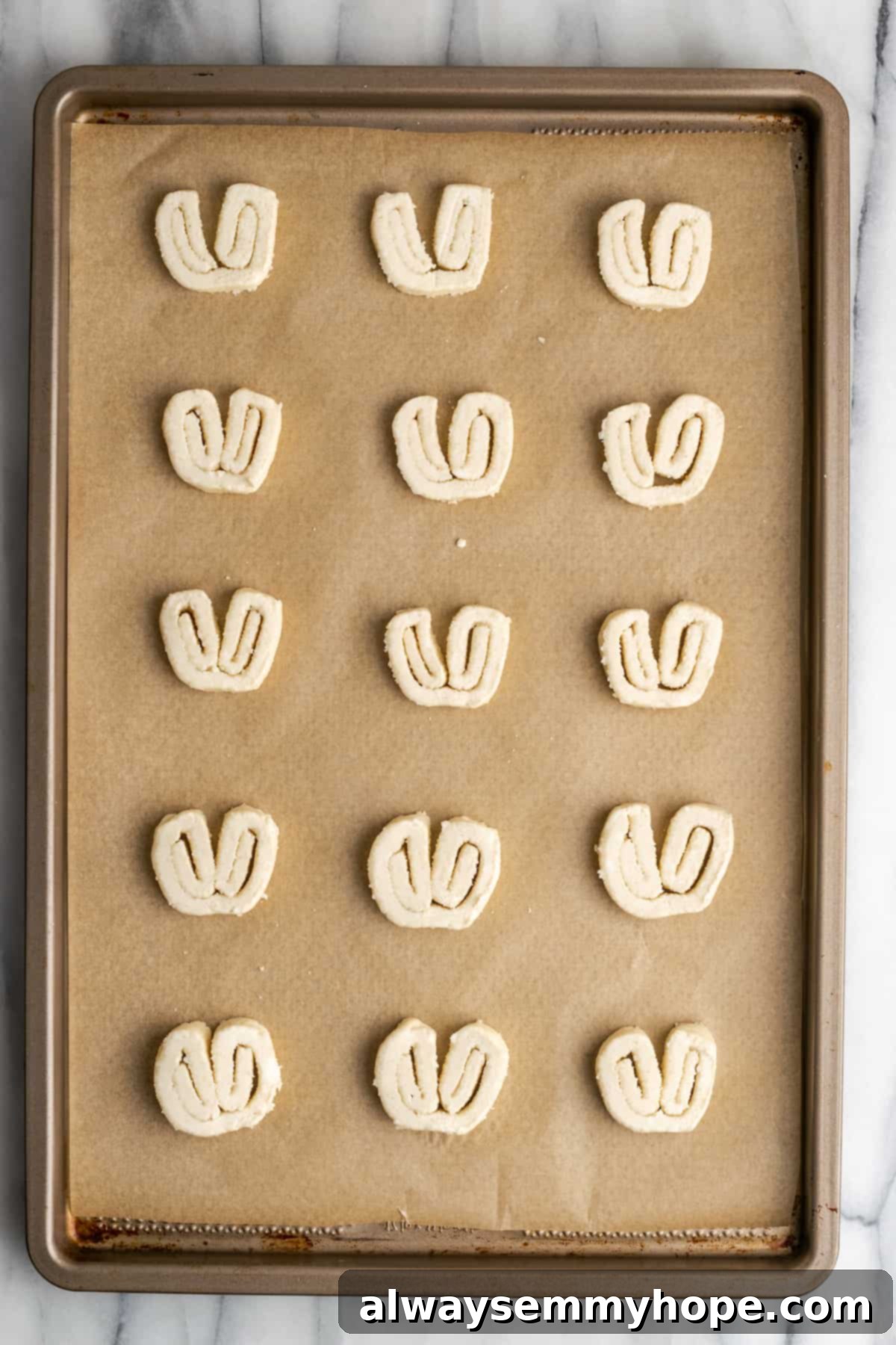 15 unbaked puff pastry palmiers on a parchment paper lined baking sheet