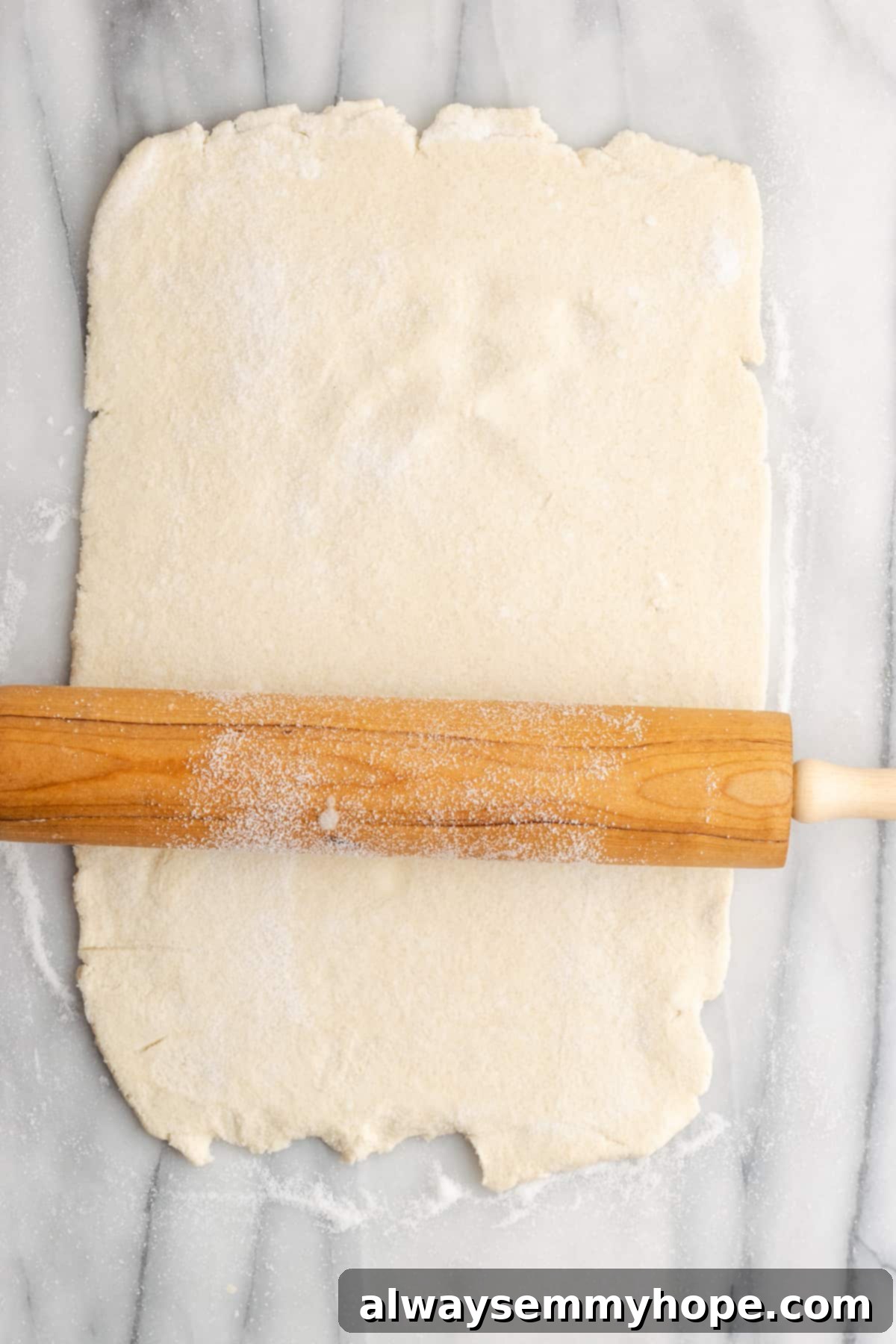 A rectangle of puff pastry with a rolling pin on it