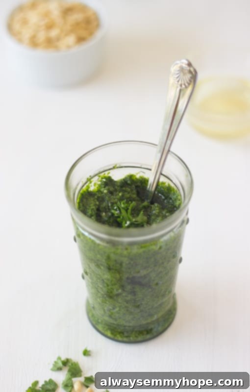 Parsley pesto in a glass jar with a spoon.