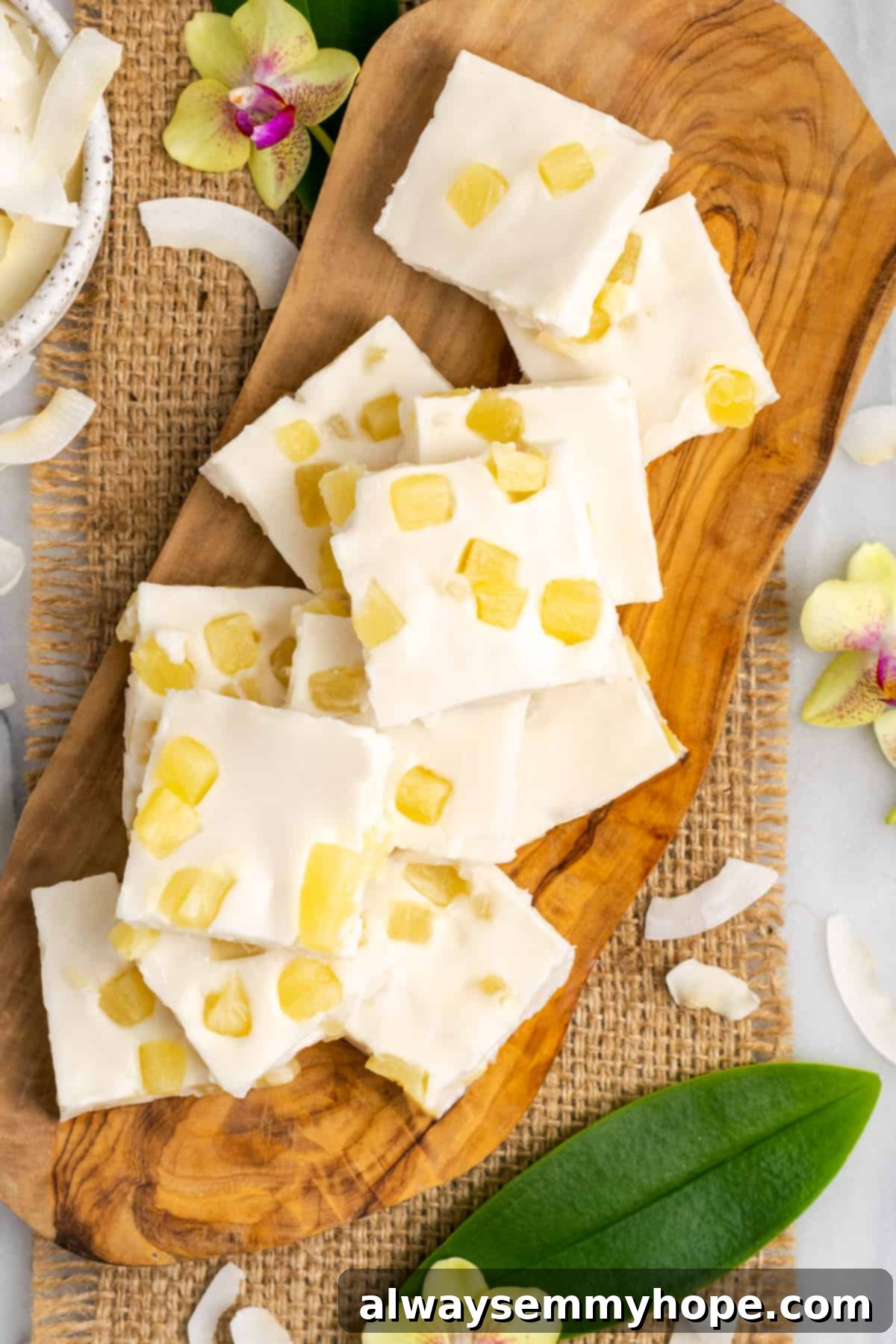 Hawaiian Coconut Haupia 2 Beautifully cut Haupia slices arranged on a rustic wooden platter, showcasing their creamy texture and the golden pineapple pieces.