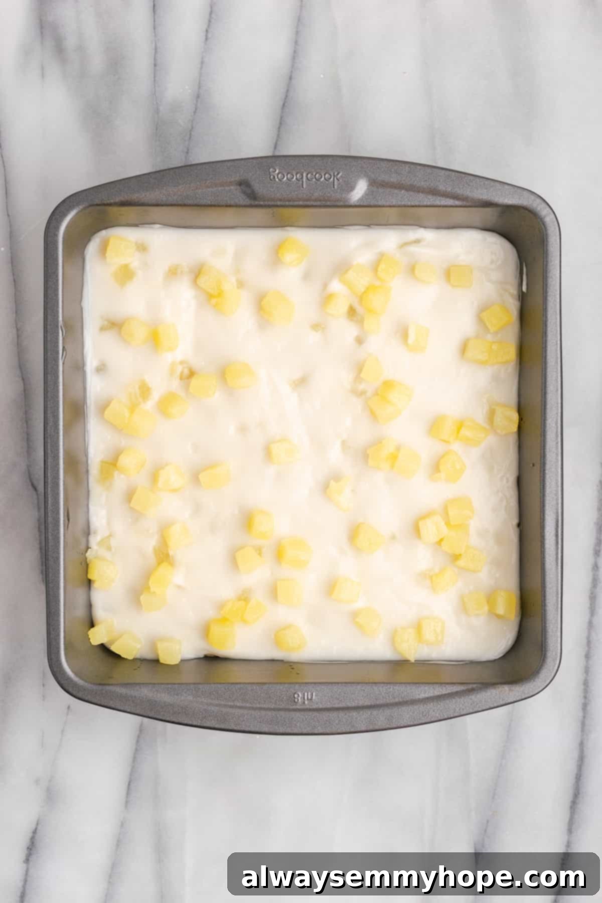 Hawaiian Coconut Haupia 12 Overhead view of the haupia in a metal pan, now topped with the remaining pineapple pieces, gently pressed in.