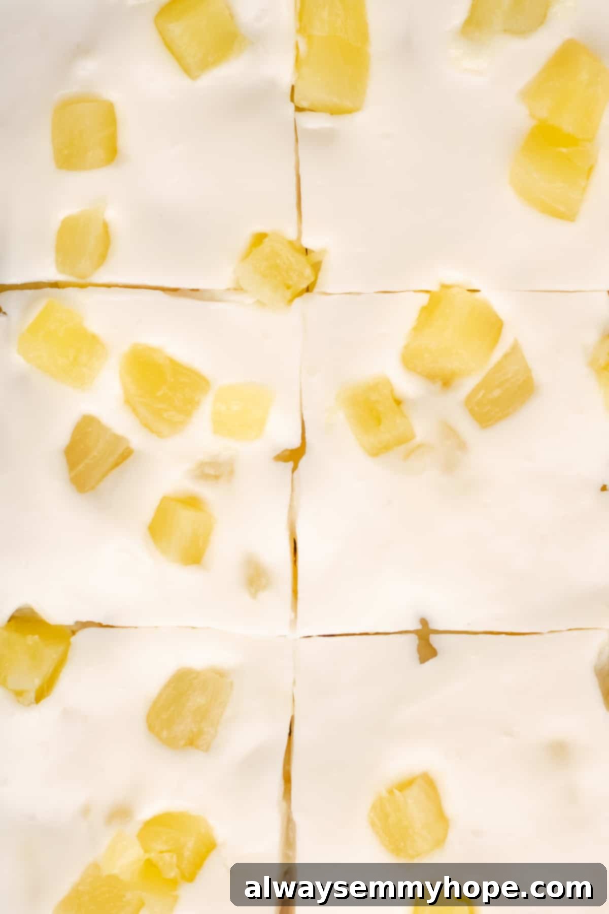 Hawaiian Coconut Haupia 13 Several neat squares of sliced pineapple haupia, showcasing the golden pineapple embedded within the creamy white coconut base, ready to be served.