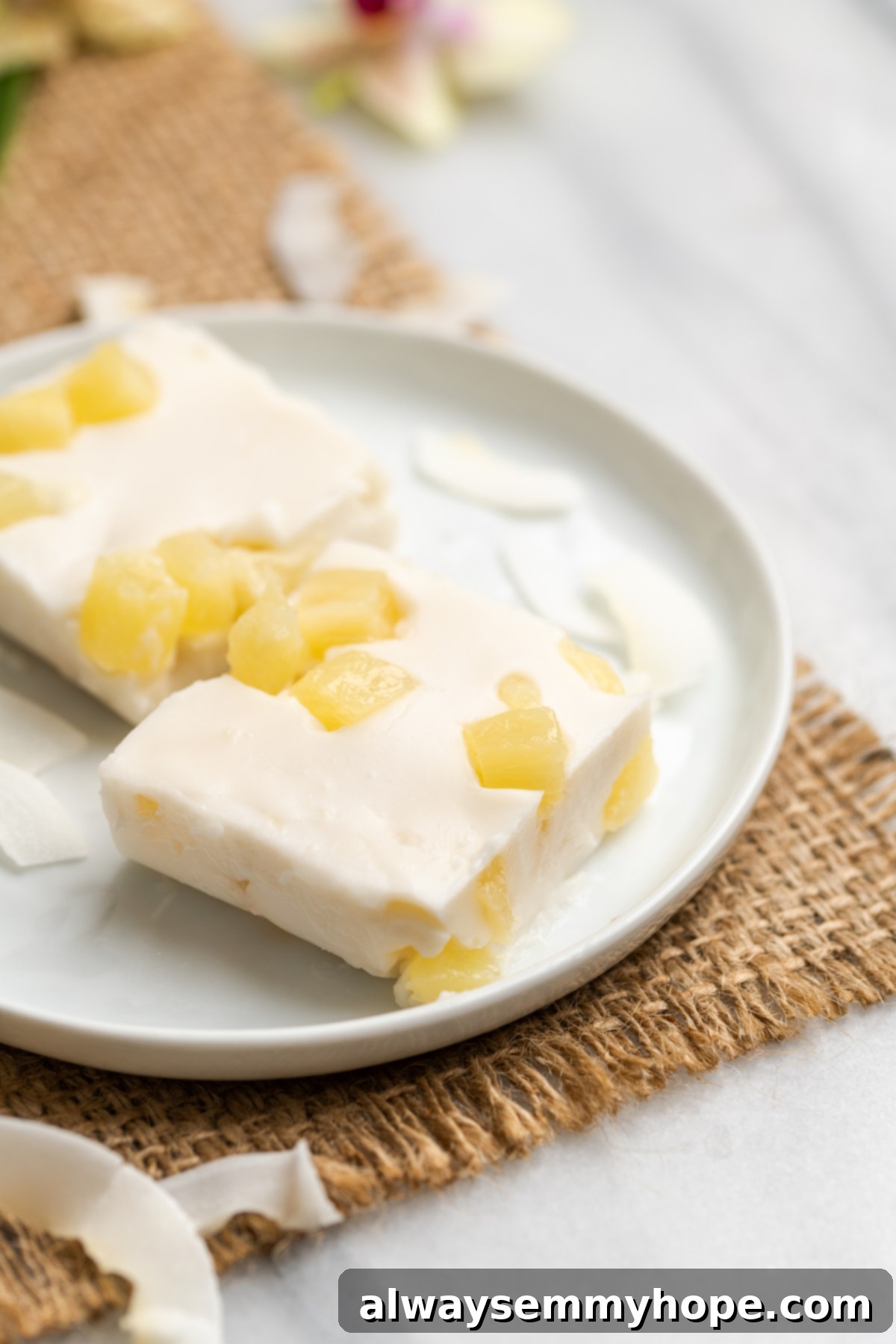 Hawaiian Coconut Haupia 3 Two perfectly cut squares of haupia on a white plate, highlighting its smooth, firm texture, ready to be enjoyed.