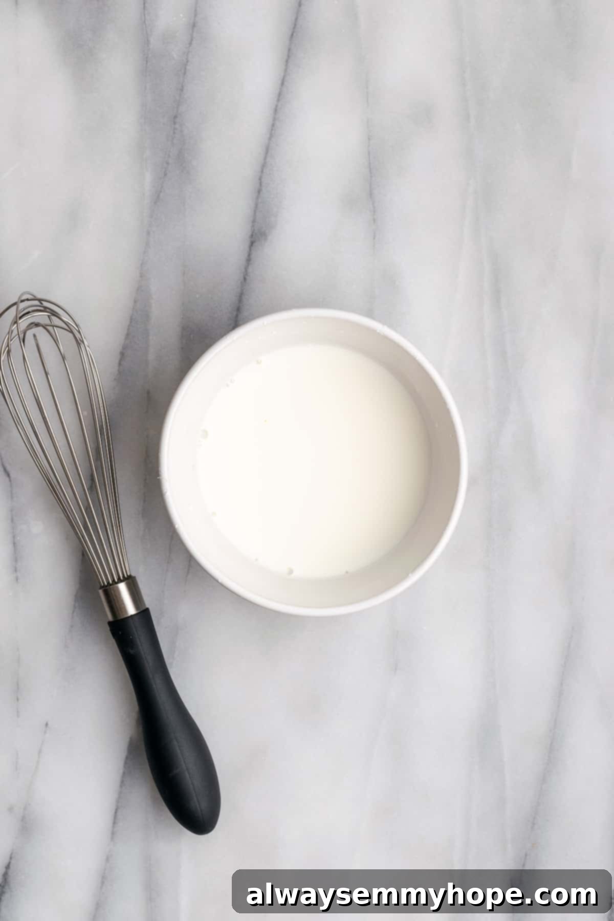 Hawaiian Coconut Haupia 7 A small bowl holding a smooth cornstarch slurry, prepared with a whisk, ready to be added to the haupia mixture.