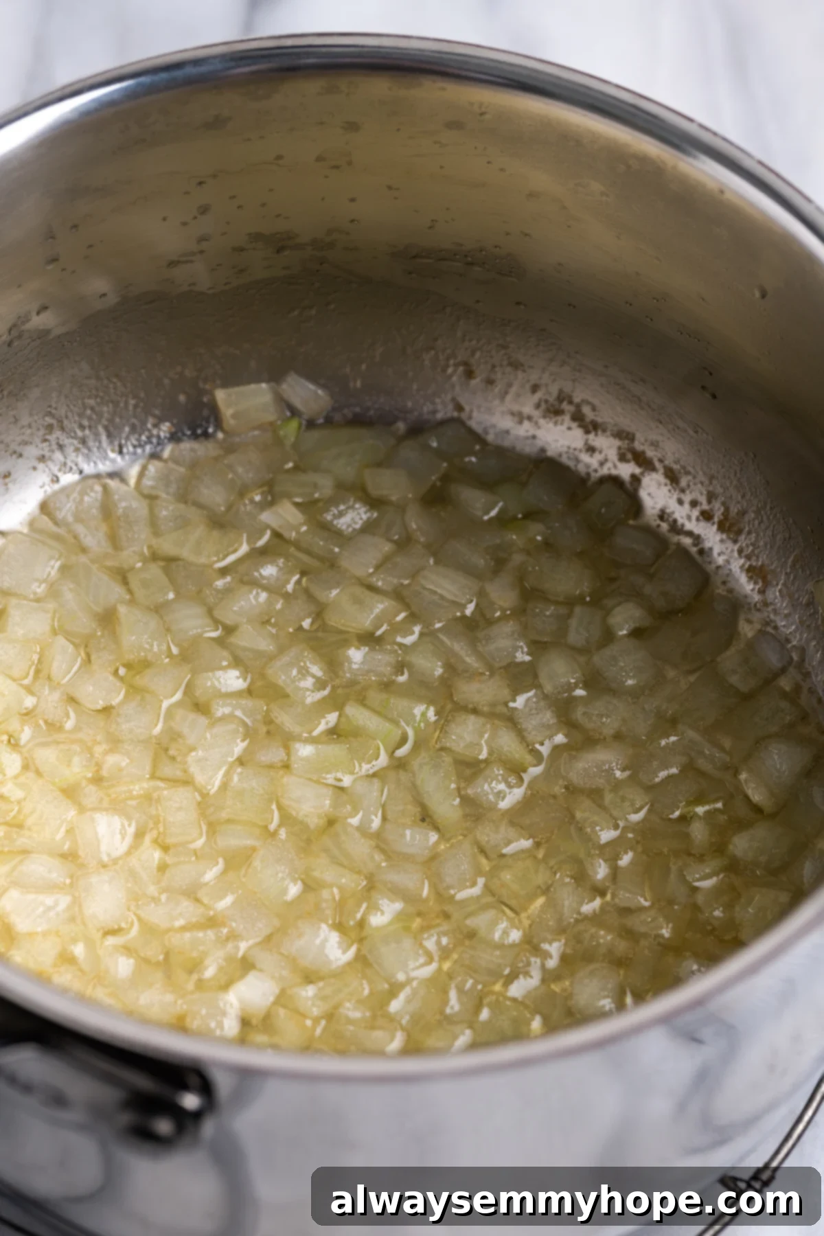 My recipe for vegan creamed corn is an easy way to make this crowd-pleemed dish without the dairy milk and butter! Finely diced onions sautéing in vegan butter in a pot