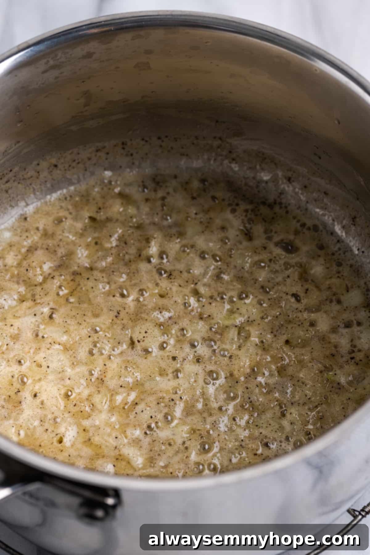 My recipe for vegan creamed corn is an easy way to make this crowd-pleasing side dish without the dairy milk and butter! Vegan butter and onions cooking in pot, forming the base of the sauce